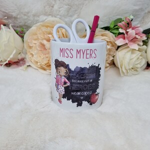 May include: White ceramic pencil holder with a black and white illustration of a teacher with the text "Miss Myers" and "Teachers because not all heroes wear capes!"