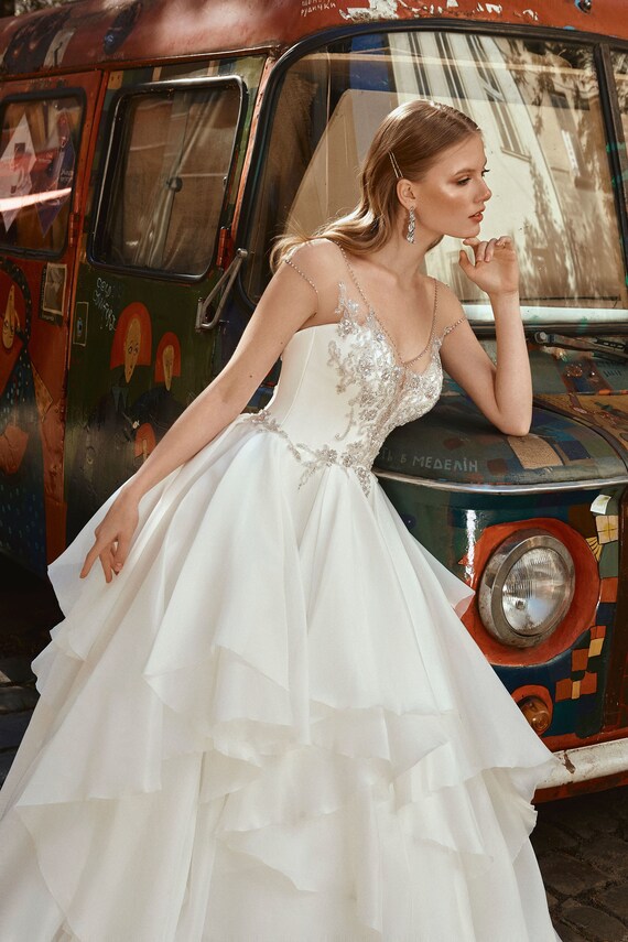 Embroidered Bodice Plunging Neckline Multi Layered Ruffled Skirt Organza Ball Gown Wedding Dress with Beaded Edge Sheer Sleeves