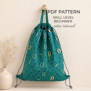 May include: A teal drawstring backpack featuring a repeating pattern of stylised oval shapes in shades of yellow and dark blue. The bag includes grey cord straps and text that reads PDF PATTERN, SKILL LEVEL BEGINNER, and video tutorial.