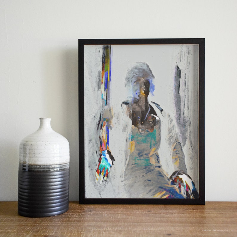 May include: Abstract art print in a black frame. The artwork features a figure with a white coat and colorful accents. A ceramic vase with a black and white design sits to the left of the framed art.