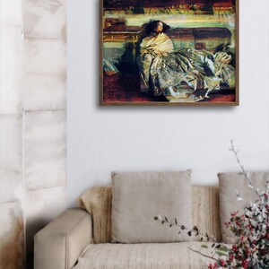 May include: A framed artwork depicts a person draped in a yellow shawl, seated on a couch. The painting features a palette of muted greens, browns, and yellows, with visible brushstrokes. The artwork is displayed above a beige couch with matching pillows.