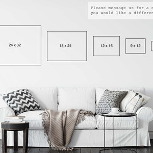 May include: A white sofa with decorative pillows and a blanket, with framed art prints of various sizes on the wall. The prints are labeled with dimensions: 24 x 32 inches, 18 x 24 inches, 12 x 16 inches, 9 x 12 inches, and 6 x 8 inches. Text on the wall says "Please message us for a quote if you would like a different size!"