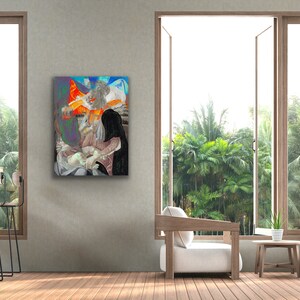 May include: A framed artwork featuring a religious scene with figures in shades of white, black, and orange. The artwork is displayed on a gray wall, with a window and outdoor view in the background. The room includes a chair and side table.
