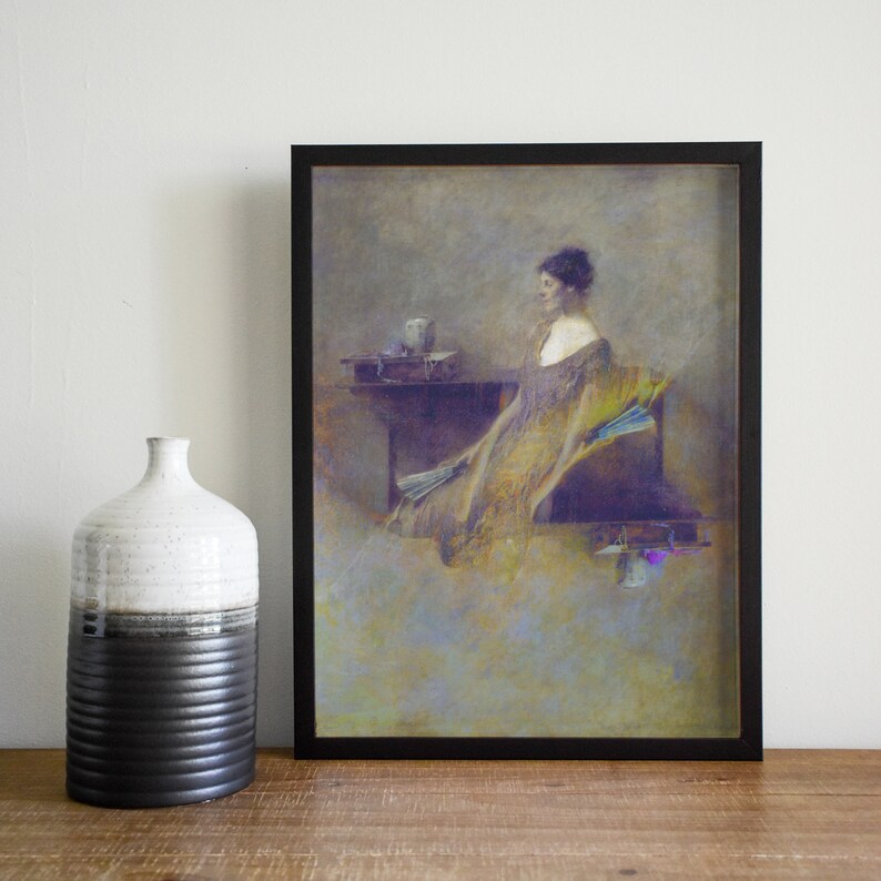 May include: Framed art print depicting a woman in a flowing gown, holding a fan. The artwork uses muted gold, purple, and blue tones. A decorative vase with black and white sections is to the left of the framed print.