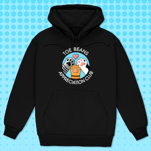 May include: Black hoodie with a white circle graphic that says "Toe Beans Appreciation Club" with three cat paws inside the circle. The paws are grey, white, and orange.