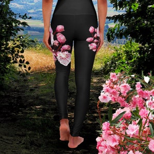 May include: Black leggings with a floral print of pink and white flowers. The leggings are fitted and have a high waist.