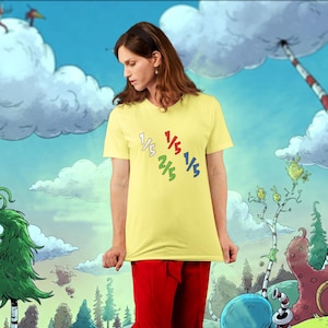 May include: A yellow t-shirt with a graphic of fractions, 1/5, 2/5, 1/5, 1/5, in a circle. The person wearing the shirt is standing in front of a cartoon background.