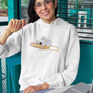 May include: White hoodie featuring a graphic of a koala sleeping on a loading bar that reads "LOADING".