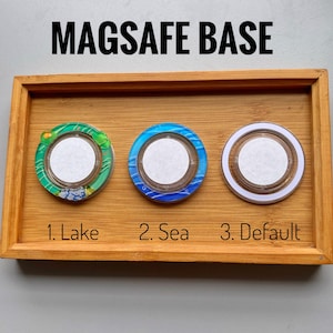 May include: Three MagSafe base accessories with different designs. One is green and white, labeled "Lake", another is blue and white, labeled "Sea", and the third is white and brown, labeled "Default". All are circular with a white center.