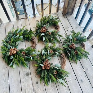 Corona navideña de media luna, pino artificial, eucalipto, follaje, piñas, decoración navideña de invierno, estilo rústico boscoso, adorno de puerta de hoja perenne. imagen 5