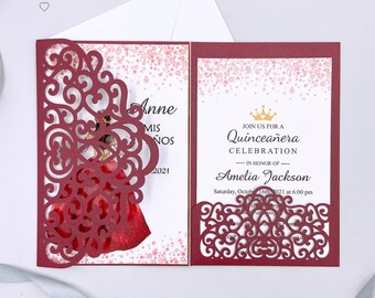 May include: Burgundy red laser cut invitation with a gold crown and the text "Join us for a Quinceañera Celebration in honor of Amelia Jackson. Saturday, October 16th 2021 at 6:00 pm".