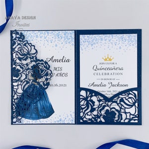 Op de afbeelding: Een blauwe en witte lasergesneden uitnodiging met een bloemenontwerp en een silhouet van een meisje in een blauwe jurk. De tekst op de uitnodiging luidt "Amelia MIS XV AÑOS 10.16.2021" en "JOIN US FOR A Quinceañera CELEBRATION - IN HONOR OF - Amelia Jackson October 16th, 2021 at Pica Plaza"