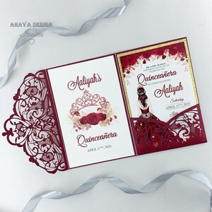 Op de afbeelding: Bordeauxkleurige lasergesneden uitnodiging met een witte inleg. De uitnodiging heeft een bloemmotief met een kroon en de tekst "Aaliyah's Quinceañera April 17th, 2025". De inleg heeft een gouden glitterachtergrond en de tekst "Mr. & Mrs. Franco Cordially Invite You To Celebrate The Quinceañera Of Their Daughter Aaliyah Saturday April 17th, 2025 Mass"