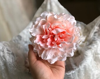 Puede incluir: Una sola flor de peonía artificial grande, de color rosa y blanco. La flor está hecha de tela suave y tiene un aspecto realista.