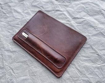 May include: A brown leather case with a stitched pocket for a stylus.