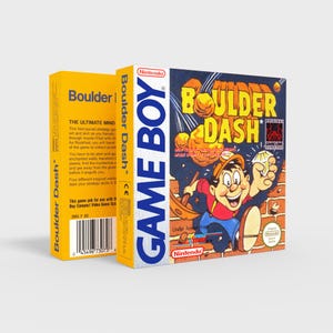 Può includere: Una cartuccia Nintendo Game Boy gialla e blu con il testo "Boulder Dash" e un'immagine di un personaggio dei cartoni animati che tiene un diamante. Il testo "The Ultimate Mind" è sul retro della cartuccia.
