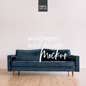 May include: A dark blue velvet sofa with wooden legs sits in front of a white wall. The text "wallpaper wall decals Mockup" is written in white on the wall.