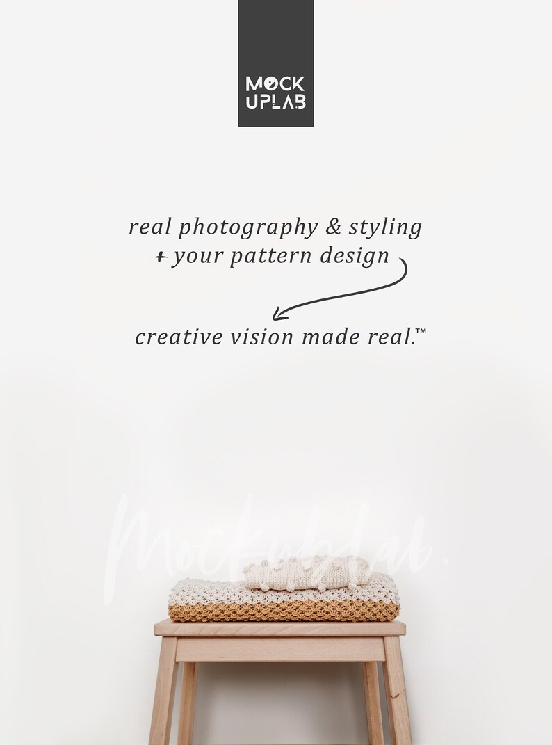 May include: A white wall with the text "MOCK UPLAB" in black. Below the text is the phrase "real photography & styling + your pattern design" in black. An arrow points to the text "creative vision made real." A wooden stool with a white and beige knitted blanket on top.