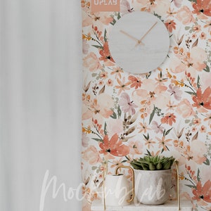 Pu&ograve; includere: Un muro bianco con una carta da parati floreale con fiori ad acquerello rosa, arancio e verde. Un orologio bianco con lancette nere &egrave; appeso al muro. Un piccolo scaffale con una cornice in metallo dorato contiene un annaffiatoio bianco e una pianta grassa in vaso.