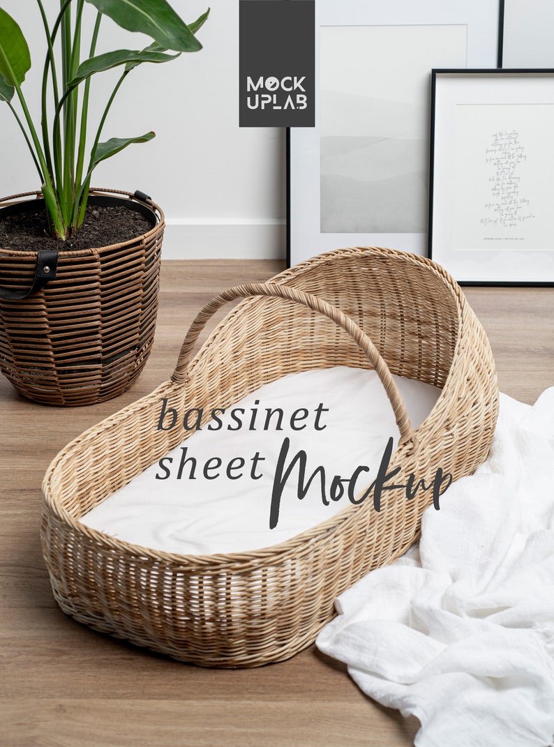 K&ouml;nnte beinhalten: Ein Weidenkorb-Babybett mit einem wei&szlig;en Laken im Inneren. Das Babybett steht auf einem Holzboden mit einer wei&szlig;en Decke daneben. Der Text "bassinet sheet Mockup" ist auf das Laken geschrieben.