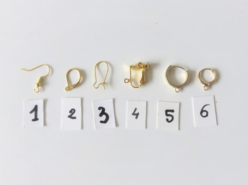 May include: Six different types of earring findings, numbered 1 through 6, on a white background. The findings are all gold-toned metal.