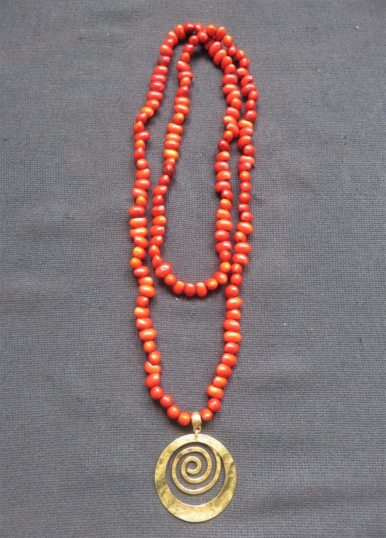 necklace natural red seeds and hammered copper medallion spiral
