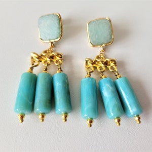 May include: Gold dangle earrings with turquoise blue stone and beads.