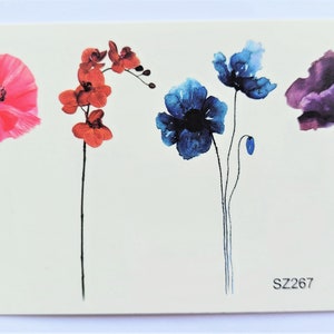 Peut inclure: Une feuille de tatouages temporaires représentant cinq motifs de fleurs à l'aquarelle : un coquelicot rose, une orchidée rouge, un coquelicot bleu, une fleur bleue et un coquelicot violet. La feuille est étiquetée avec le code "SZ267".