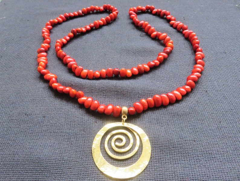 necklace natural red seeds and hammered copper medallion spiral