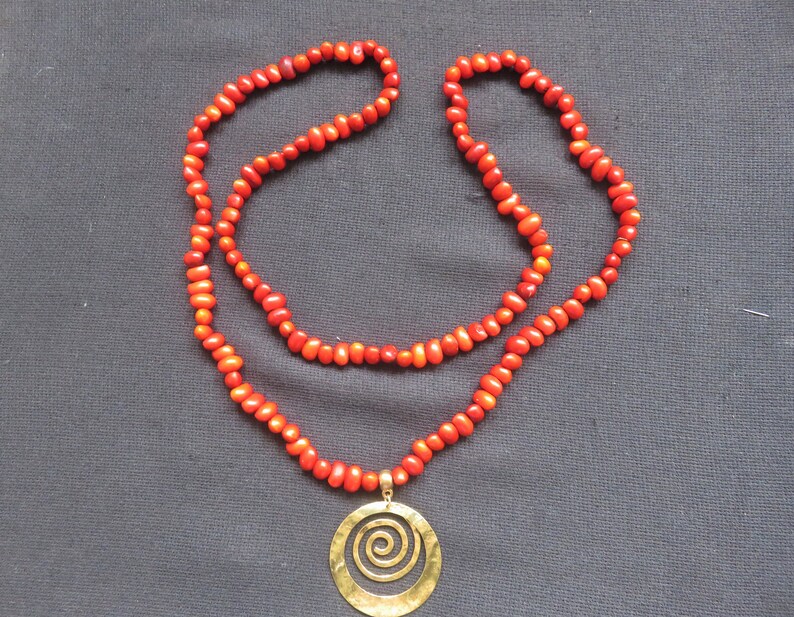 necklace natural red seeds and hammered copper medallion spiral