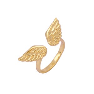 Op de afbeelding: Gouden ring met twee engelenvleugels op de band. De vleugels zijn gedetailleerd met een textuur van veren.