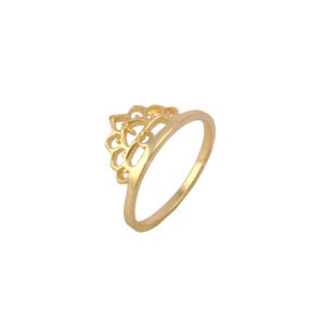 May include: A gold-colored ring with a floral design. The ring features an openwork pattern of curved shapes, creating a delicate and ornamental appearance. The band is smooth and simple, complementing the intricate design of the ring's centerpiece.