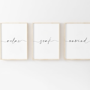 May include: Three framed prints with the words "relax", "soak", and "unwind" written in cursive script.