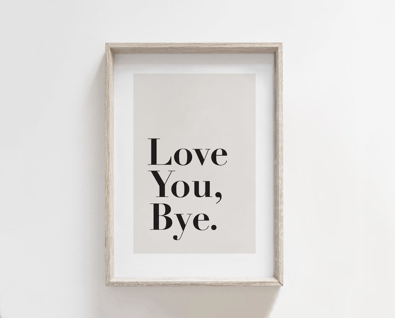 May include: A framed print with a beige background and black text that reads "Love You, Bye."