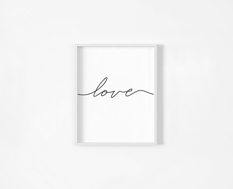 May include: A white framed print with the word "love" written in black cursive script.