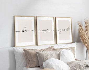 May include: Three framed prints with a light pink background and black cursive text that reads "be our guest".