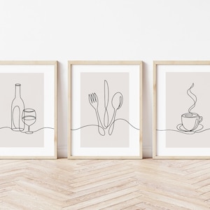 May include: Three minimalist line art prints in wooden frames. The prints depict a wine bottle and glass, a fork, knife, and spoon, and a steaming cup of coffee.