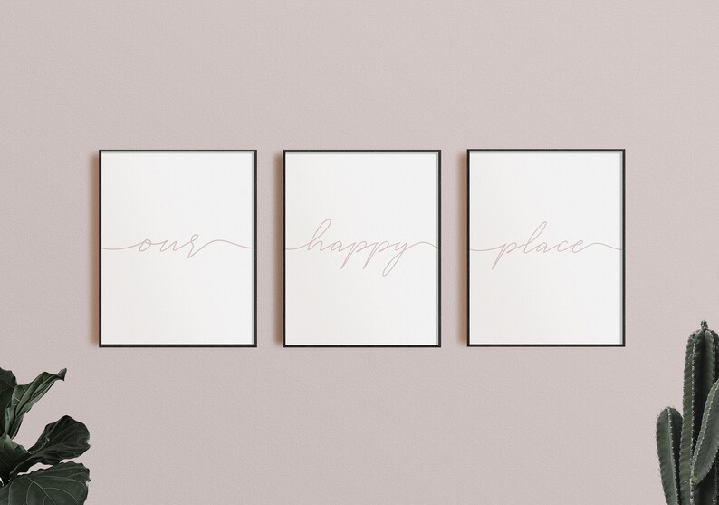 May include: Three framed prints with the words "our", "happy", and "place" written in cursive script. The prints are hung on a light pink wall.