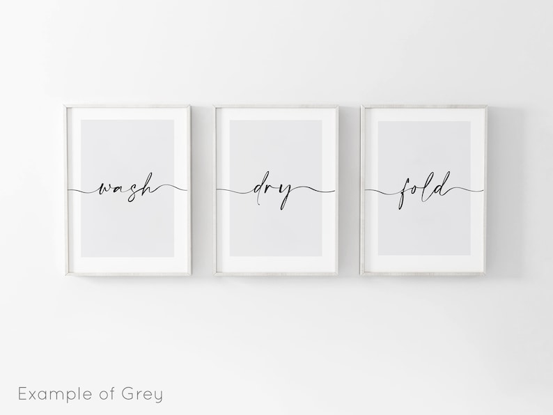 May include: Three framed prints with the words "wash", "dry", and "fold" written in a cursive font on a light gray background.