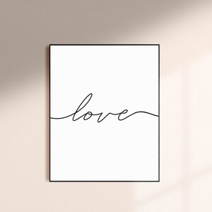 May include: A black and white minimalist print with the word "love" written in a single continuous line.