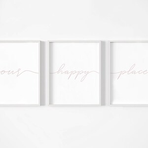 May include: Three white framed prints with the words "our happy place" written in pink cursive script.