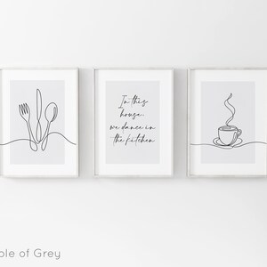 Peut inclure: Trois impressions encadr&eacute;es avec un art lin&eacute;aire minimaliste. L'une pr&eacute;sente une fourchette, un couteau et une cuill&egrave;re, une autre porte le texte "In this house, we dance in the kitchen", et la troisi&egrave;me repr&eacute;sente une tasse de caf&eacute; avec de la vapeur.