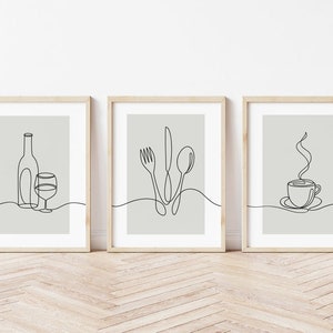May include: Three minimalist line art prints in wooden frames. The prints depict a wine bottle and glass, a fork, knife, and spoon, and a steaming cup of coffee.