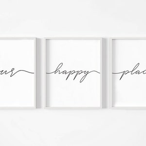 May include: Three white framed prints with black calligraphy. The prints read "our happy place" in a continuous line.