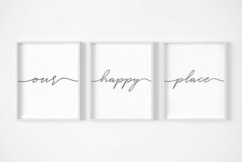 May include: Three white framed prints with black calligraphy. The prints read "our happy place" in a continuous line.
