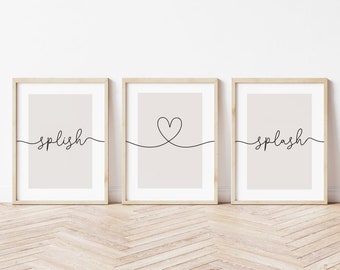 May include: Three framed prints with a minimalist design. The left print features the word "splish" in cursive script. The middle print features a simple heart shape drawn with a single line. The right print features the word "splash" in cursive script.