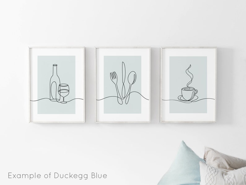 May include: Three minimalist line art prints in white frames with a light blue background. The prints depict a bottle of wine and a glass, a fork, knife, and spoon, and a steaming cup of coffee.