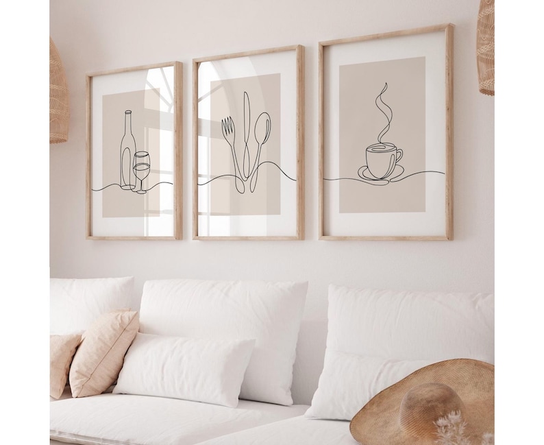 May include: Three minimalist line art prints in wooden frames. The prints feature a bottle of wine and a glass, a fork, knife, and spoon, and a steaming cup of coffee.