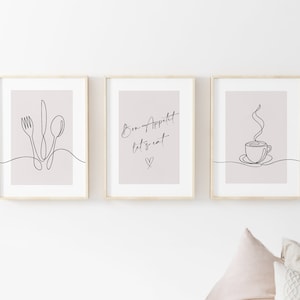 K&ouml;nnte beinhalten: Drei gerahmte Kunstdrucke mit minimalistischen Strichzeichnungen. Einer zeigt eine Gabel, ein Messer und einen L&ouml;ffel, ein anderer sagt "Bon Appetit let's eat" mit einem Herzen, und der dritte zeigt eine dampfende Kaffeetasse. Die Rahmen sind aus hellem Holz, der Hintergrund ist hellbeige.