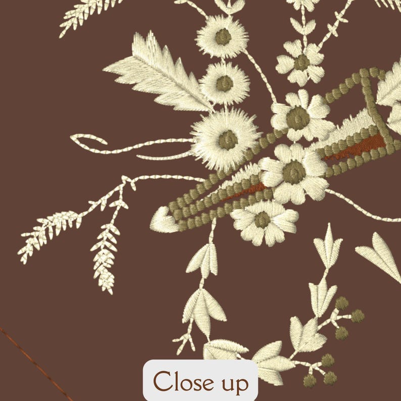 May include: Close-up of a brown fabric with white embroidered flowers and leaves. The embroidery includes a small, brown, rectangular shape with a white outline.